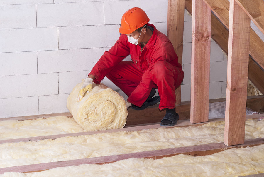 a man installing firberglass insulation